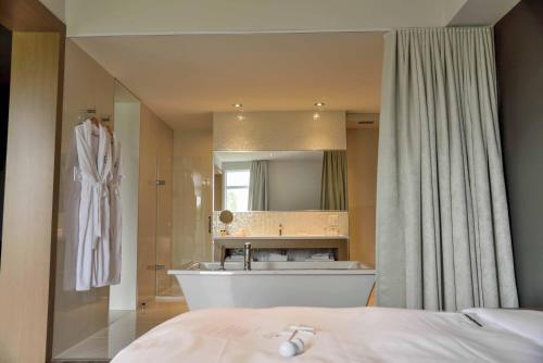 BeaucevilleLa Cache du Golf的带浴缸、水槽和镜子的浴室