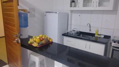 马塞约Estúdio Ibiza II的厨房在柜台上放一碗水果