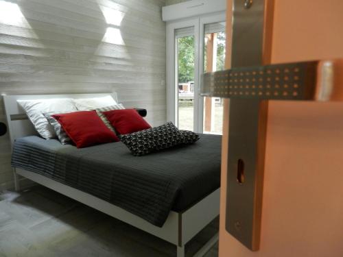 Saint-Laurent-de-la-PréeLa Désirade的一间卧室配有红色和黑色枕头的床