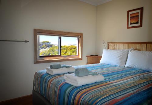 塞杜纳Ceduna Shelly Beach Caravan Park的一间卧室配有一张大床和毛巾