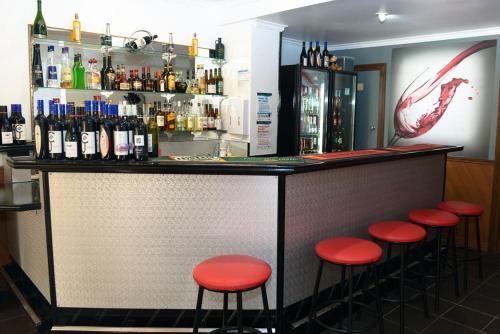 汉密尔顿班蒂阔特哈密顿汽车旅馆的吧台前有红色凳子的酒吧