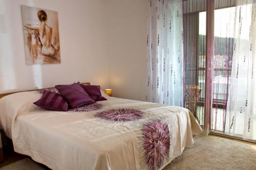 斯普利特Apartment Belavista的一间卧室配有一张带紫色枕头的床和窗户。