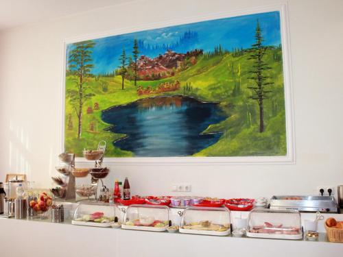 奥芬巴赫艾瑞纳酒店的一张桌子,上面有食物,墙上有画