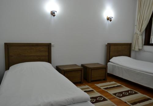 雅西Casa de Oaspeți Sfântul Nicolae的一间卧室设有两张床和两个床头柜