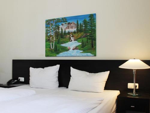 奥芬巴赫艾瑞纳酒店的在酒店房间床上方的绘画