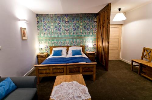 克拉科夫Pensjonat Pola的一间卧室配有一张带蓝色床单的床和一张沙发