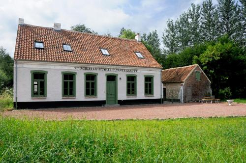 Vurste't Schippershuis的白色的建筑,有红色的屋顶和桌子