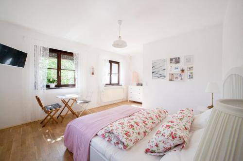 滨湖波德斯多夫Bio Archehof - Zur Grube的卧室拥有白色的墙壁,配有带枕头的床铺。