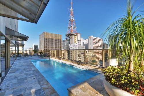 圣保罗保利斯塔行政全美酒店的一座城市天际线建筑屋顶上的游泳池