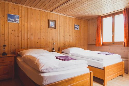 库尔瓦尔登The Lodge的木墙客房的两张床