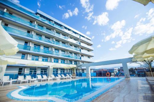 阿德勒Hotel El Paraiso的大楼前设有游泳池的酒店