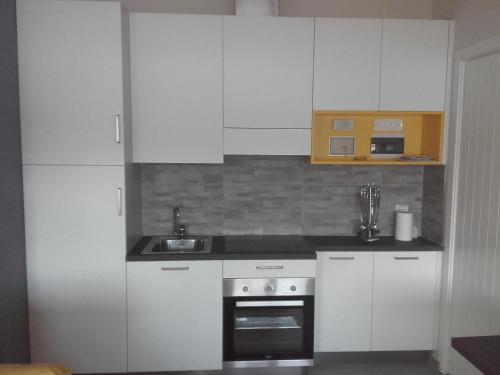 卡尼洛瑞维拉Appartamento Wow的厨房配有白色橱柜和水槽