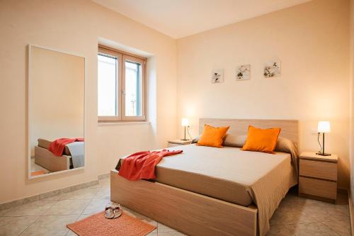 拉维罗Casa Vacanze La Trinità的一间卧室配有带橙色枕头和镜子的床