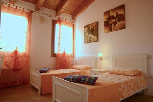 SambrusonAgriturismo Dartora的一间卧室设有两张床和窗户。