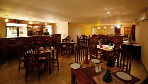 马翁莫科洛汽车旅馆的一间带木桌椅的餐厅和一间酒吧