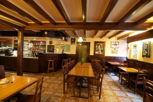Cressier克鲁瓦-布兰奇酒店的一间带木桌椅的餐厅和一间酒吧