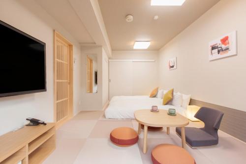 东京东京目黑佑天寺酒店的客房设有1张床、1张桌子和1台电视。