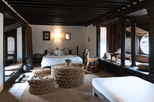 巴克塔普尔皮亚科克宾馆的一间卧室配有一张床和两张搁脚凳