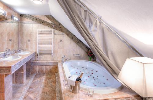 米库洛夫塔扎尔米库洛夫膳食公寓的一间带大浴缸和两个盥洗盆的浴室