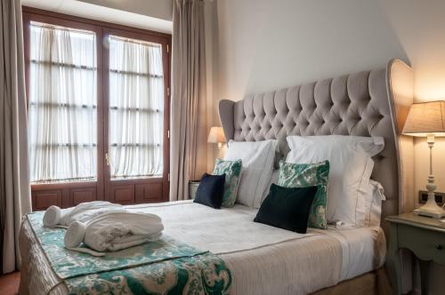 塞维利亚皮内罗宫酒店的一间卧室配有一张大床和大床头板