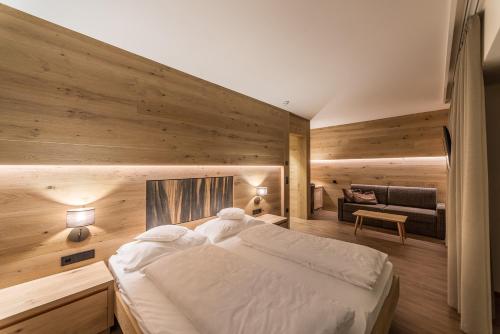 塞尔瓦迪加尔代纳山谷Hotel Garni Dolomieu的一间卧室配有一张大床和一张沙发