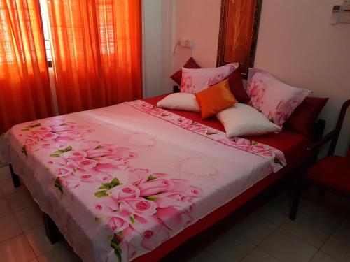 科伦坡塔姆比利岛斯图斯旅舍的一张上面有粉红色玫瑰的床