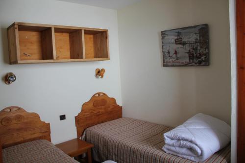葱仁谷Résidence Montana Premier的一间带两张床和橱柜的小卧室