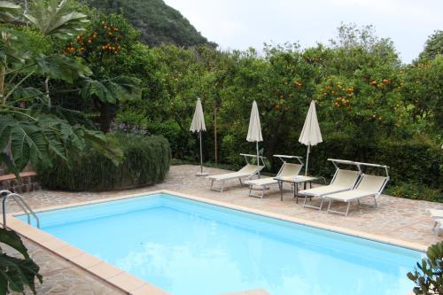 圣安吉洛弗拉维亚别墅酒店的一个带桌椅和遮阳伞的游泳池