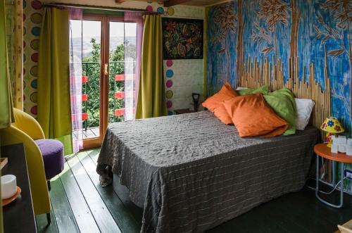 LentellaCasa sull'Albero的一间卧室设有一张带色彩缤纷墙壁的床和窗户。