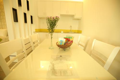 土龙木市新公寓式酒店的白色的餐桌上放着花瓶