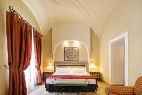 梅里达伊露尼翁梅里达宫酒店的一间卧室设有一张床和一个大窗户