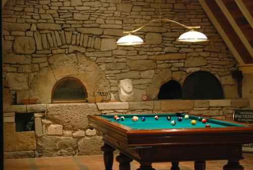 罗卡马杜尔Belveyre à Rocamadour的石墙房间内的台球桌