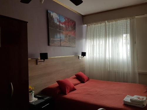 布宜诺斯艾利斯圣卡洛斯酒店的一间卧室设有红色的床和窗户。