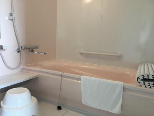 中富良野町布兰科芙蓉佩蒂特酒店的带浴缸和毛巾的浴室