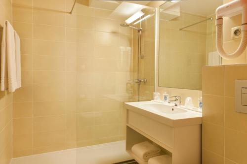利戈尔塞姆基里亚德斯塔伯格林格斯谢姆酒店的一间带水槽、淋浴和镜子的浴室