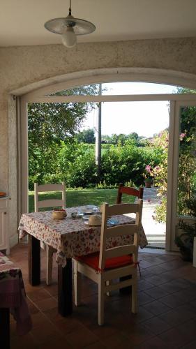 Villa Vicentina卡萨佩里尼住宿加早餐旅馆的餐桌、两把椅子和窗户