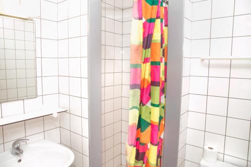 布鲁日欧罗巴旅舍的浴室设有五颜六色的淋浴帘,毗邻水槽