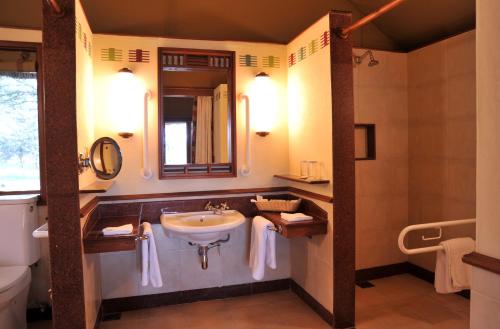 纳纽基甜水塞雷纳营地山林小屋的一间带水槽、卫生间和镜子的浴室