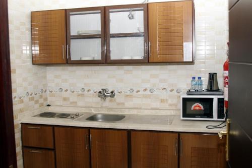 阿尔布亚米Dar Al Khaleej Hotel Apartments的厨房配有水槽和微波炉
