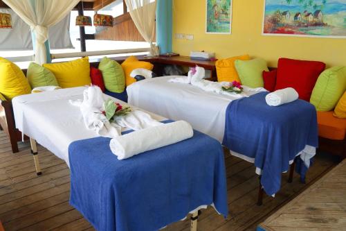 尼格瑞尔棕榈度假村的一间设有三张床的客房,备有毛巾