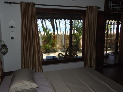 阿勒皮Alleppey Beach Garden的一间卧室设有一张床和一个大窗户