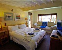 德尔斯特鲁姆Delagoa Cottage Dullstroom的卧室配有一张白色的大床和一张沙发。