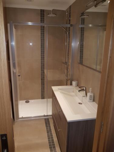 波尔蒂芒达罗沙公寓的带淋浴、盥洗盆和浴缸的浴室