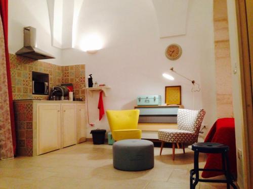 奥斯图尼L'alcova di Garibaldi的客厅配有黄色椅子和桌子