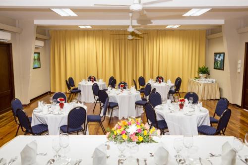 金斯敦利瓜尼亚俱乐部酒店的宴会厅配有白色的桌椅