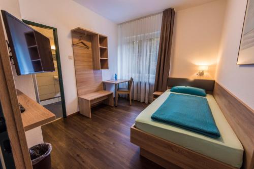 亚琛巴克拉酒店的小房间设有一张床和一张桌子