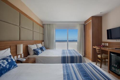 里约热内卢阿特兰蒂寇海滩酒店的酒店客房设有两张床和电视。