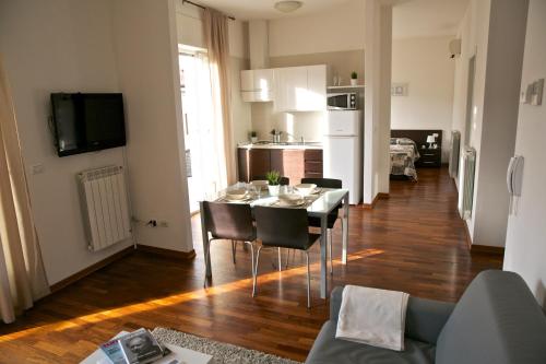 的里雅斯特乐特拉萨住宅酒店的厨房以及带桌椅的用餐室。