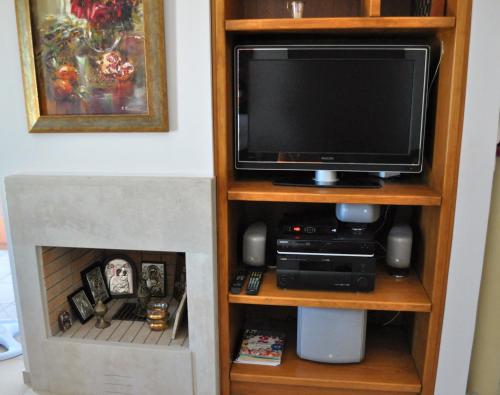 杰拉尼Gerani Private Villa的带壁炉的书架上的电视