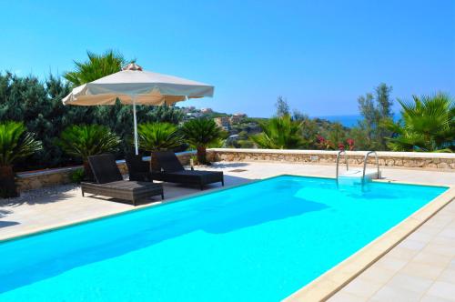 杰拉尼Gerani Private Villa的一个带遮阳伞、两把椅子和遮阳伞的游泳池